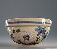Side view showing floral painting and blue rim band