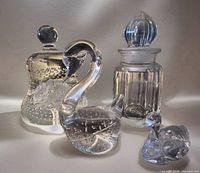 Group shot of all five crystal pieces: two swans, bell, bottle and stopper