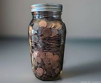 Full view of jar filled with pennies, lid visible