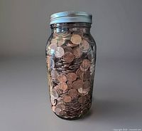Front view of glass jar filled with pennies