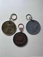 All three coin keychains grouped for size and style reference