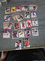 Overview of circa 25 mixed 1990s hockey trading cards spread on tabletop