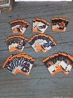 Front view of multiple stacks of orange-border Pro Set hockey cards spread on table