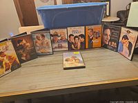 Front view of nine DVD cases including one lying flat on table