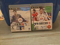 Front view of FIFA 14 and FIFA Soccer 11 PS3 game cases