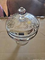 Top view of covered compote showing etched floral design, "25th" script, silver band, knob finial