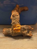 Front view of driftwood root wall hanging showing painted face