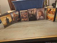All six DVD cases standing in a row on surface