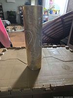 Full front view of tall cylinder vase with gold paisley pattern
