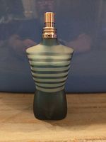 Front view of striped torso glass bottle showing overall design and atomizer