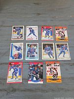All eleven Joe Sakic trading cards laid out in three rows on a tabletop