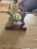 Front view of resin hummingbird and lily figurine on wood base