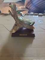 Front view showing hummingbird, flower, wooden base, nameplate
