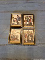 All four framed Hummel prints laid out on table
