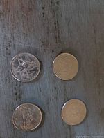 Four state quarters laid out, both obverse and reverse visible