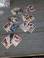 Wide view of several small stacks of hockey cards spread out on table