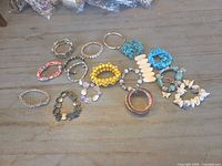 All sixteen bracelets laid out on wooden surface