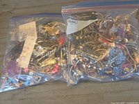 Two Ziploc bags filled with assorted jewelry pieces