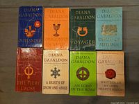 Eight main Outlander novels laid out, showing cover wear
