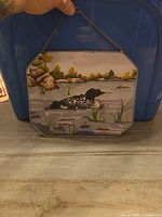 front view of painted glass wall hanging with loon scene
