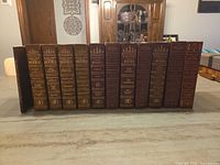Front view of 14 hardcovers showing uniform spine design