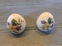 Front view of both egg-shaped shakers showing floral design