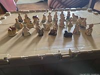 Overall view of 28 ceramic miniature figurines on a surface