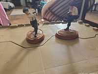 Two resin baseball kid figurines on wood bases