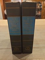 Spine view of both encyclopedia volumes showing title and publisher logo.
