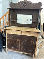 Front view of oak sideboard buffet showing carved crest, mirror, turned supports, drawers, cabinet doors, unfinished and distressed surfaces