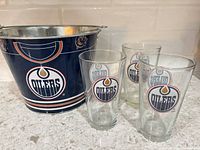 Ice bucket and three glasses displaying Edmonton Oilers logos
