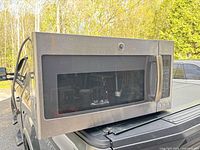 Front view of GE stainless over-the-range microwave on vehicle bed