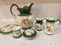 full set showing six matching green and cream floral porcelain pieces
