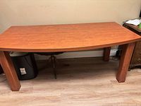 Front view of rectangular laminate executive desk with wood legs