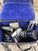 Camera, lens, flash, mini tripod and strap inside blue-lined case