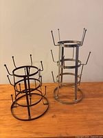 Black and silver metal mug trees standing on wooden surface