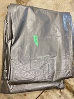 Folded black/silver tarp showing material texture and label