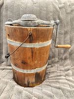 Full view of wooden bucket with crank assembly and wire handle