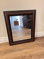 Front view of rectangular brown wood-tone framed mirror