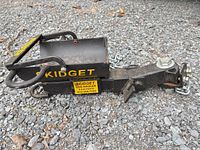 Overall view of Skidget log hauler hitch showing receiver end, chain, decals, and surface rust
