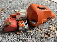 Lot overview showing chainsaw case, fuel can, oil jug, oil bottles