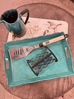 All five items arranged: pitcher, glass cutting board, tray, napkin holder, spatula