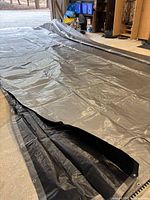 Full view of laid-out black/silver tarp showing size and grommeted edge