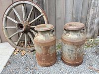 wagon wheel and two milk cans together