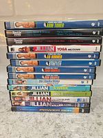 Stack of 13 workout DVDs showing all spine titles