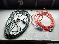 Both extension cords coiled side by side