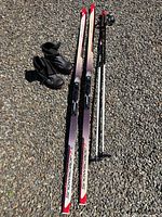 Full set showing skis, poles, boots on gravel