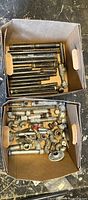 Two boxes of black and galvanized plumbing pieces