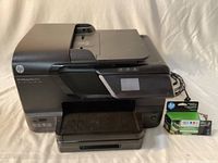 Full view of HP Officejet Pro 8600 printer with power cord and boxed HP 951 cartridge