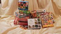 Group shot of all puzzles, OuiSi game, cylindrical puzzle, and watercolor kit